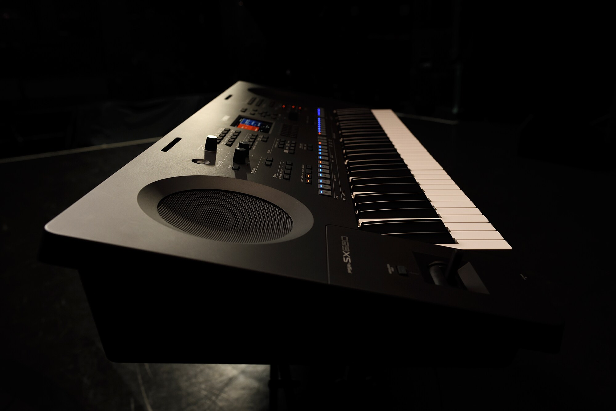 A keyboard on a stand under stage lighting