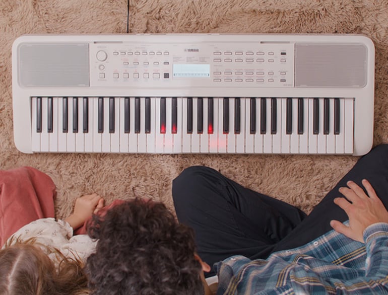 Father and daughter watch the keys on the EZ-310 glow.