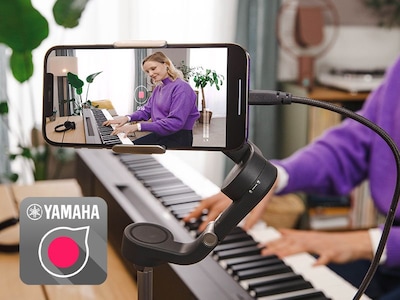 Вид значка приложения Yamaha Rec'n'Share и человека, который снимает на смартфон видео, как он играет.