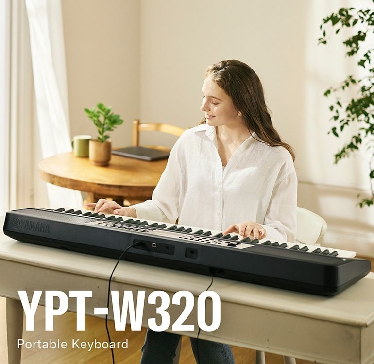 Woman absorbed in playing the YPT-W320.