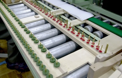 The keyframe is positioned below the keyboard. Thin paper shims are inserted underneath the red felt pieces to adjust key height.