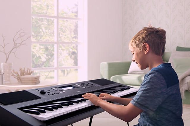 A kid playing YAMAHA PSR-E373 Portable Keyboard
